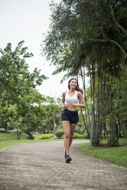 Femme jeune beau sport qui court dans le parc. Concept santé et sport.