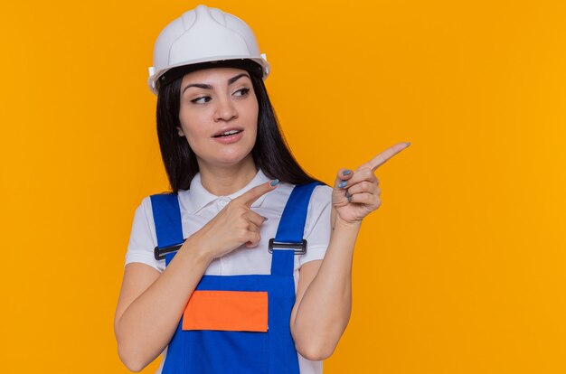 Femme jeune constructeur en uniforme de construction et casque de sécurité