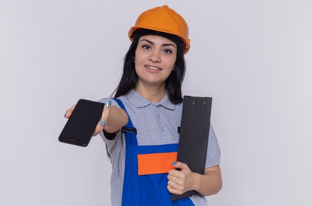 Femme jeune constructeur en uniforme de construction et casque de sécurité