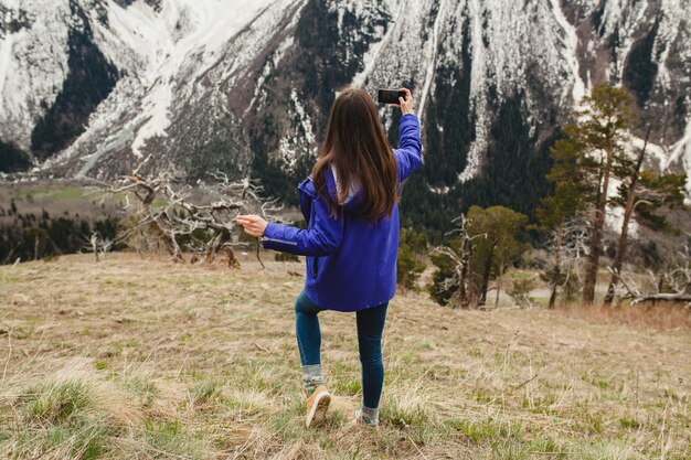 Femme jeune hipster marchant dans les montagnes