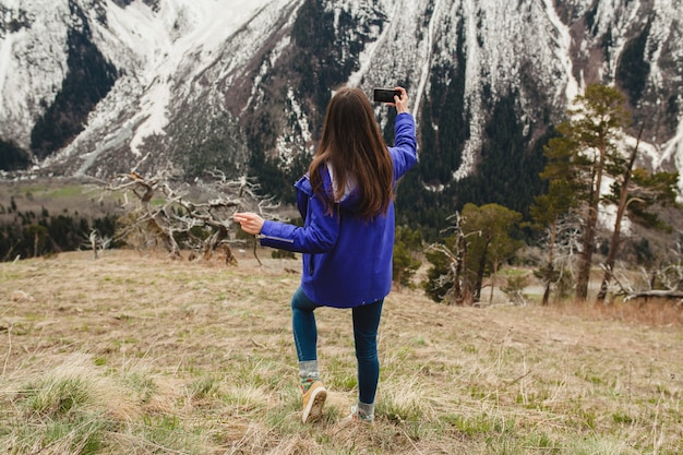 Femme jeune hipster marchant dans les montagnes