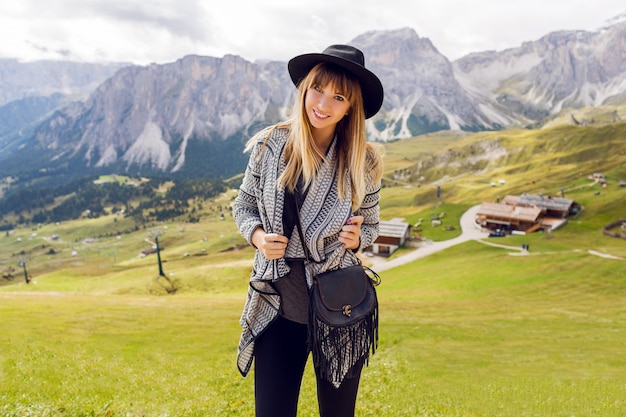 Femme jeune voyageur avec chapeau et sac à dos bénéficiant d'une vue imprenable sur la montagne