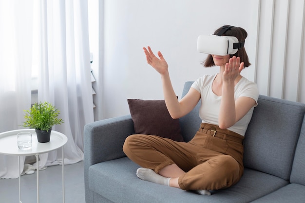 Femme jouant à un jeu vidéo tout en utilisant des lunettes vr