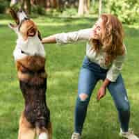 Photo gratuite femme jouant avec son chien dans le parc