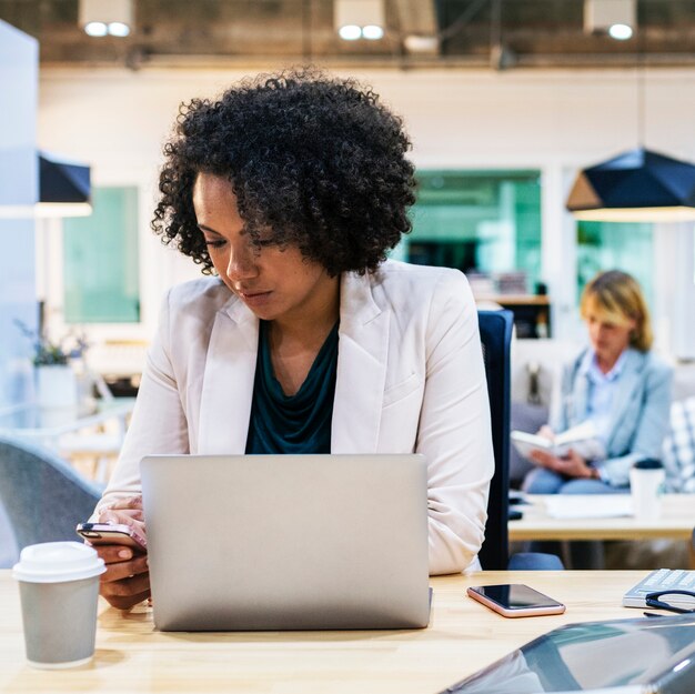 Femme jouant sur son téléphone au travail