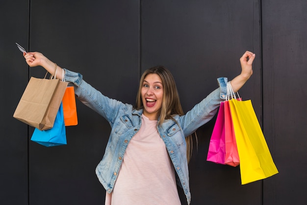 Femme joyeuse debout avec des sacs colorés