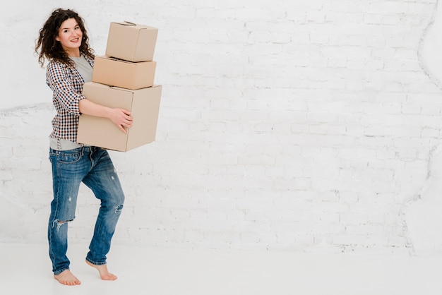 Femme joyeuse posant avec des boîtes en carton