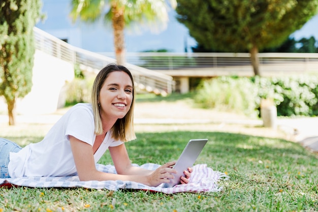 Femme joyeuse avec tablette en regardant la caméra