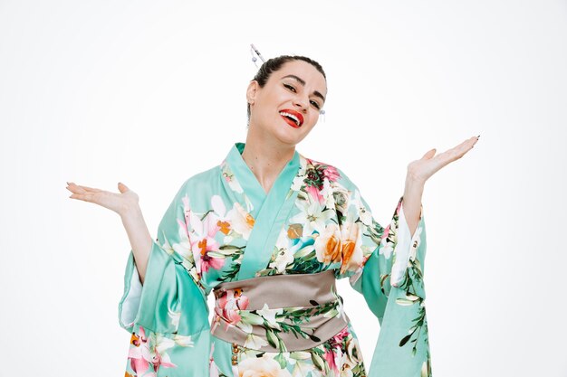 Femme en kimono japonais traditionnel heureux et heureux de lever les bras souriant largement sur blanc