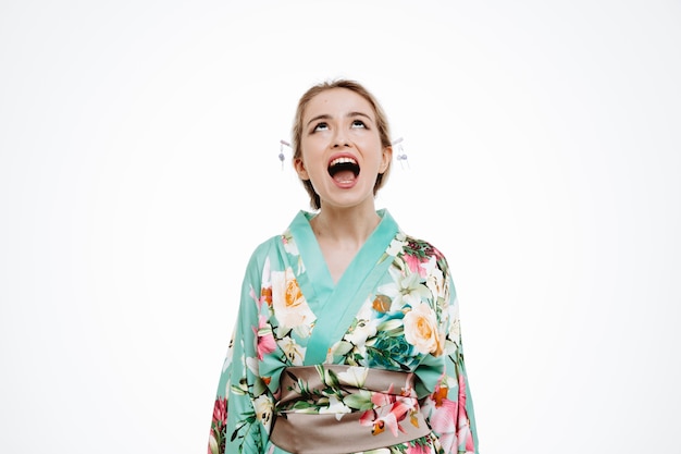Femme en kimono japonais traditionnel jusqu'à crier d'être agacé sur blanc