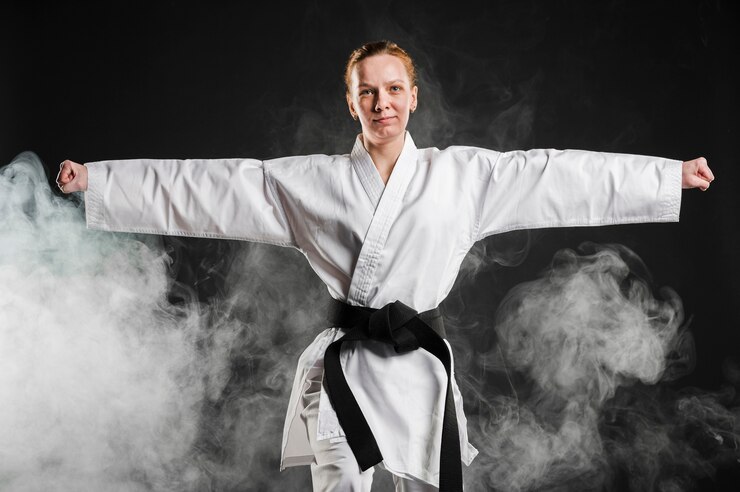 Photo gratuit femme en kimono pratiquant le taekwondo