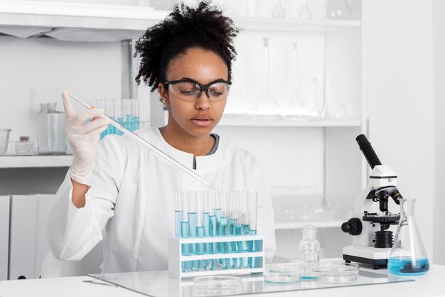 Femme en laboratoire travaillant avec microscope