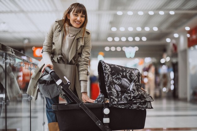 Femme avec un landau dans un centre commercial