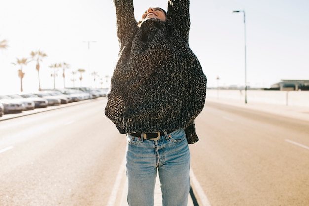 Femme levant les bras au milieu de la rue