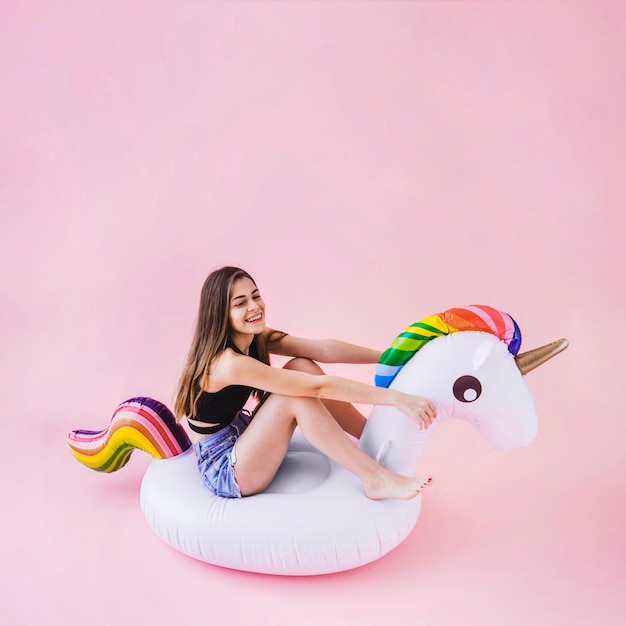 Photo gratuite femme sur une licorne gonflable