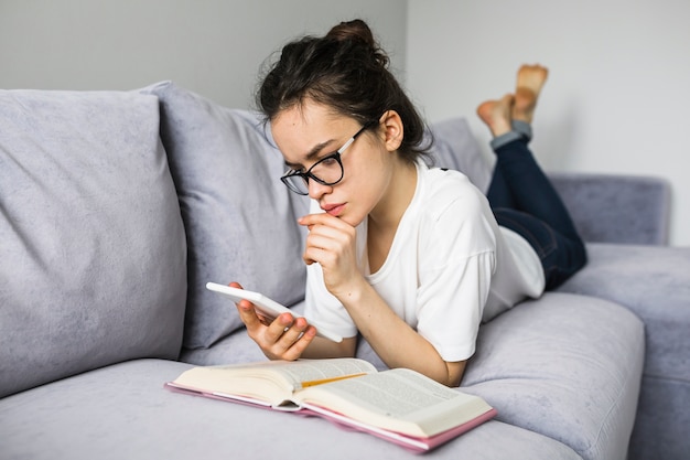 Femme lisant un e-book sur le canapé