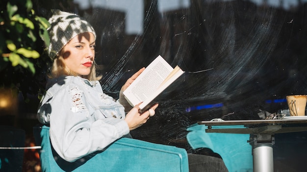 Photo gratuite femme lisant un livre au café