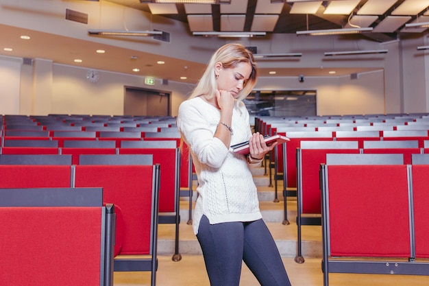 Photo gratuite femme lisant un livre dans la salle de conférence