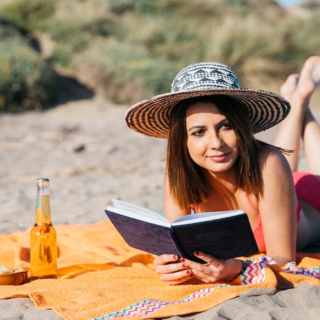 Photo gratuite femme lisant un livre à la plage