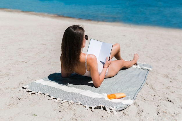 Photo gratuite femme lisant un livre près de l'eau