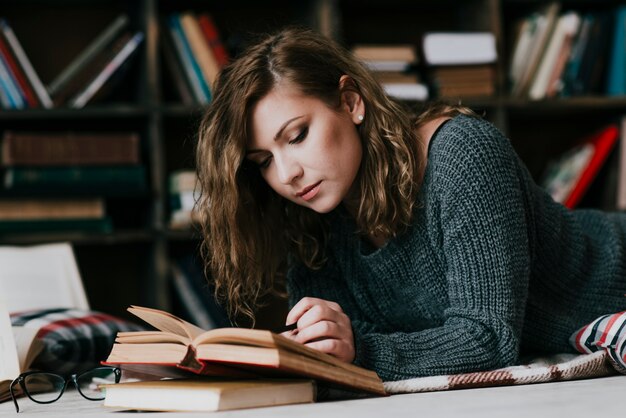 Femme lisant un livre sur le sol