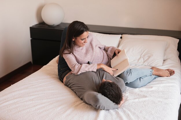 Femme lisant un livre à son mari