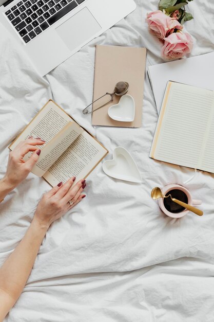 Femme lisant un roman sur son lit un dimanche après-midi