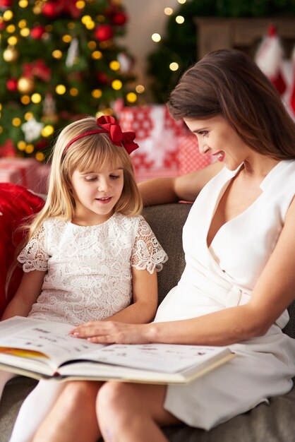 Femme lit un livre avec une fille