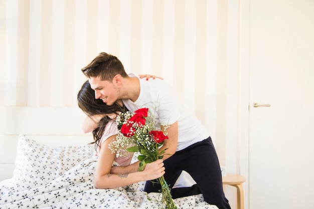 Femme sur le lit remerciant l&#39;homme pour le bouquet