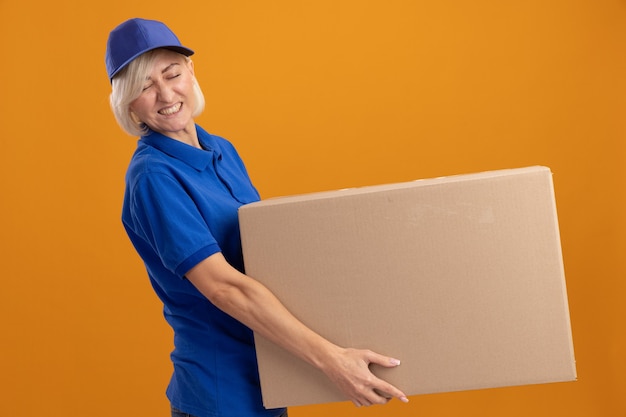 Femme de livraison blonde d'âge moyen tendu en uniforme bleu et casquette