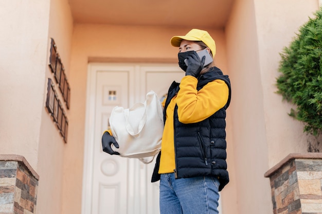 Photo gratuite femme de livraison coup moyen à la porte