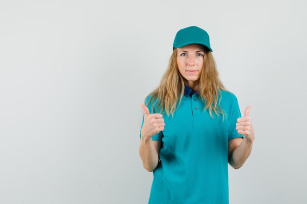 Femme de livraison montrant deux pouces vers le haut en t-shirt, casquette et à la satisfaction.