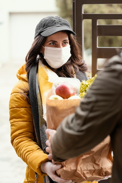 Photo gratuite femme de livraison avec paquet de nourriture