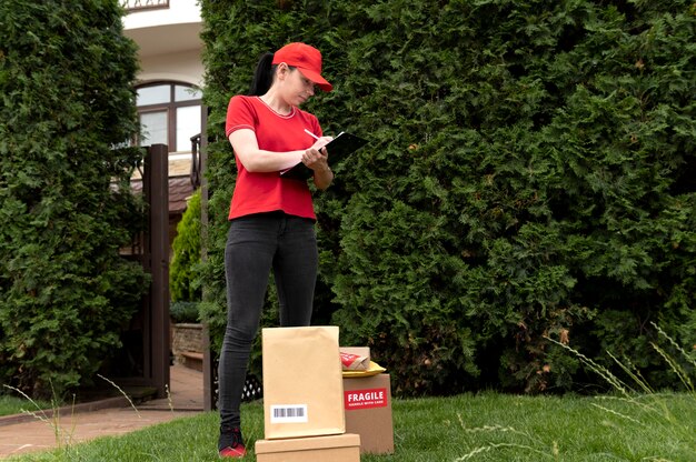 Femme de livraison de plein coup avec des packs