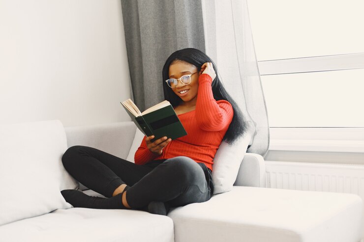 Photo gratuit femme avec un livre sur le canapé