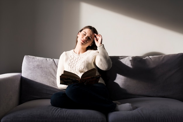 Femme avec livre avec les yeux fermés