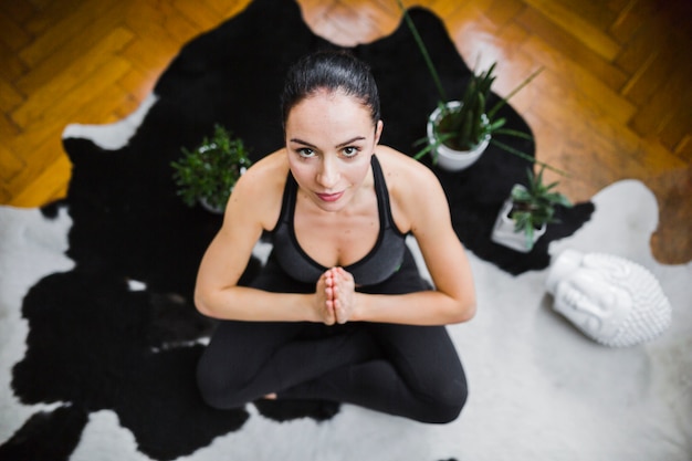 Photo gratuite femme en lotus pose en regardant la caméra