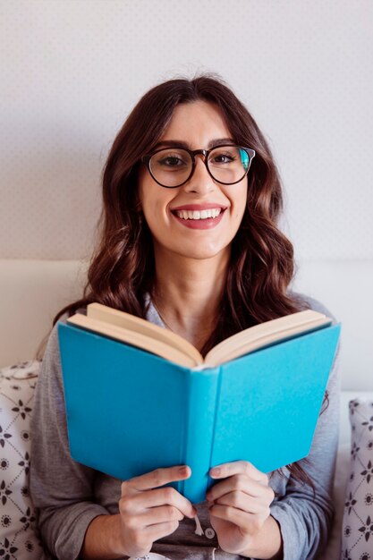 Femme à lunettes, lecture au lit