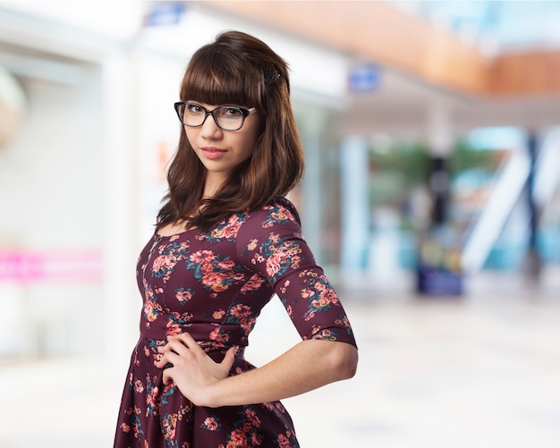 Femme avec des lunettes et une main sur la hanche