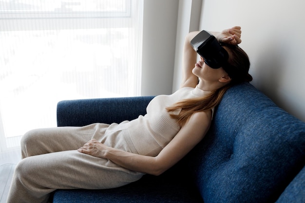 femme à lunettes de réalité virtuelle relaxante à la maison