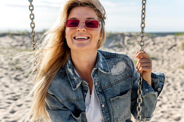 Femme, lunettes soleil, balançoire