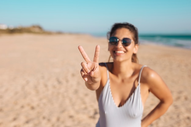 Femme à lunettes de soleil faisant v soupir