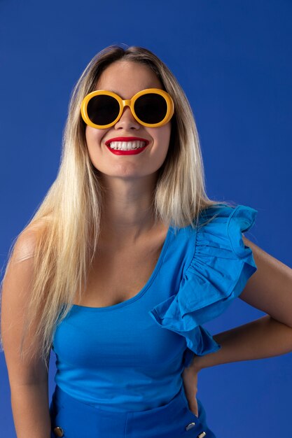 Femme avec des lunettes de soleil jaune coup moyen