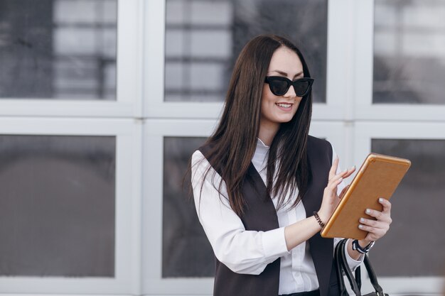 Femme avec des lunettes de soleil touchant l&#39;écran d&#39;une tablette