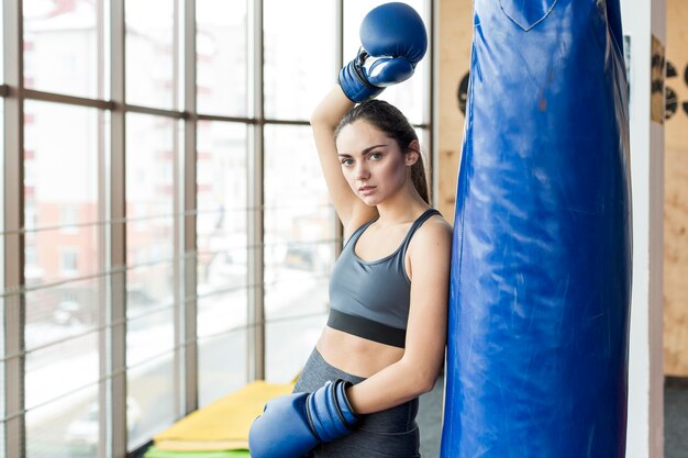 Femme avec la main dans le gant de boxe