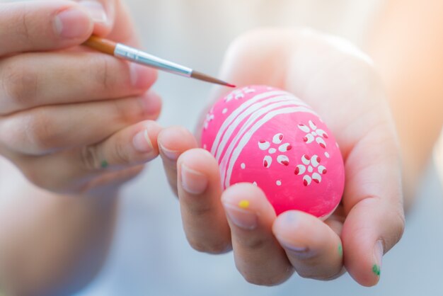 Femme main décorer les oeufs de Pâques