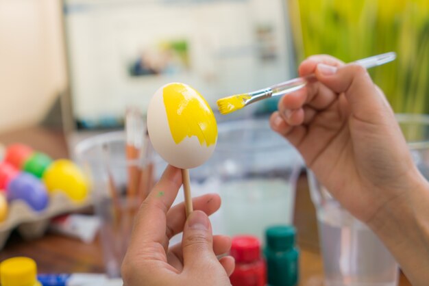 Femme main décorer les oeufs de Pâques