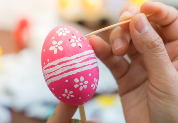 Femme main décorer les oeufs de Pâques