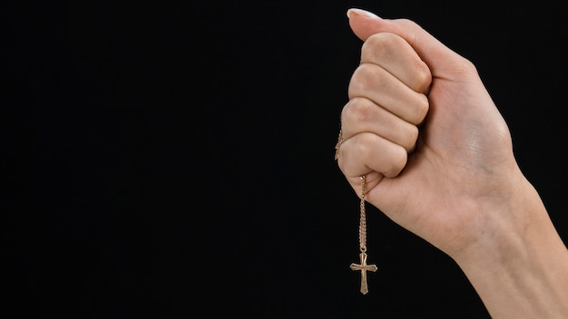 Femme main tenant collier croix avec espace copie