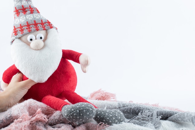 Femme main tenant la figurine du Père Noël sur une surface blanche